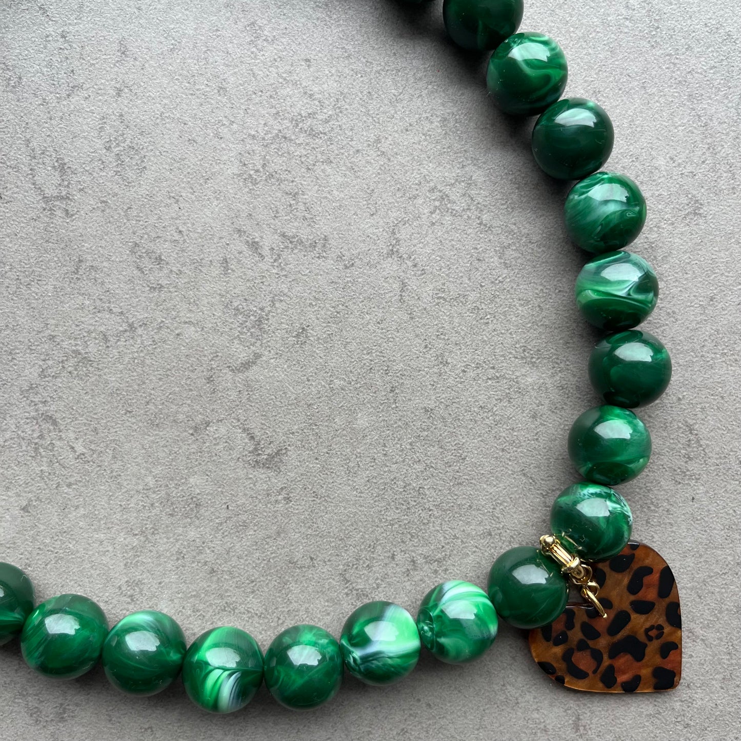 Collier Wild Love en perles rondes acrylique avec pendentif cœur léopard en acétate. Bijou tendance femme monté sur fil élastique